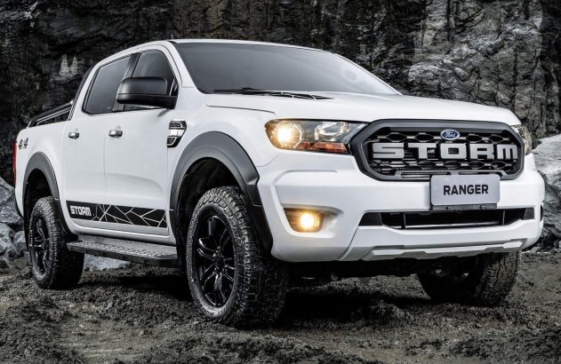 Ford Ranger Storm 4x4 branca em terreno off-road lamacento e rochoso, com faróis acesos.