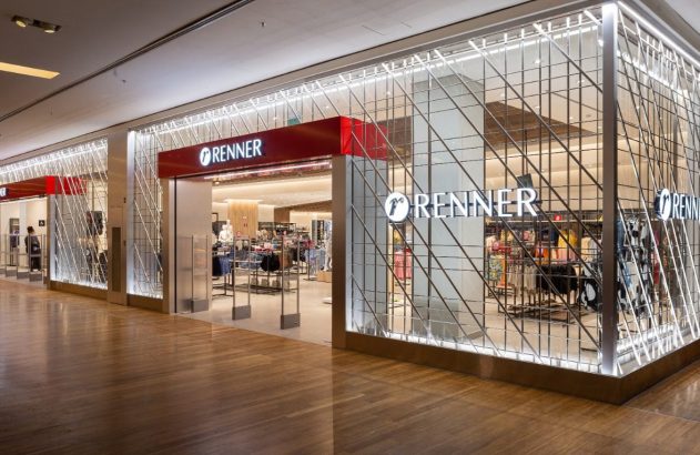 Fachada da loja Renner em shopping, com vitrines, entrada e letreiros iluminados. Chão de madeira.