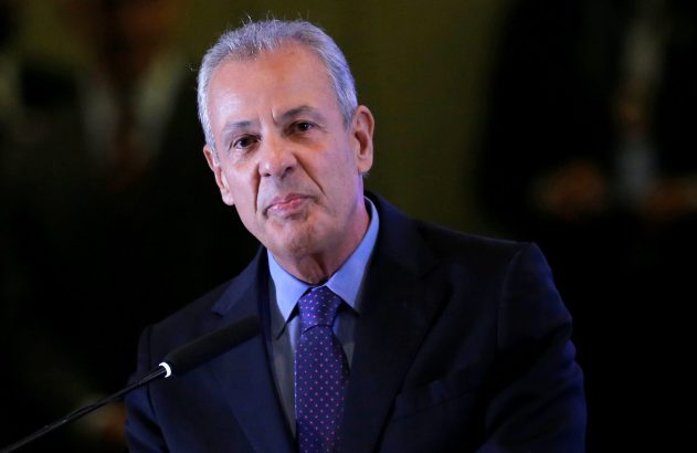 Homem de cabelos grisalhos, de terno e gravata, fala ao microfone.