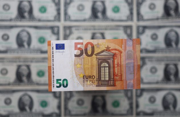 Cédula de 50 euros em primeiro plano, com notas de dólar americanas borradas ao fundo.