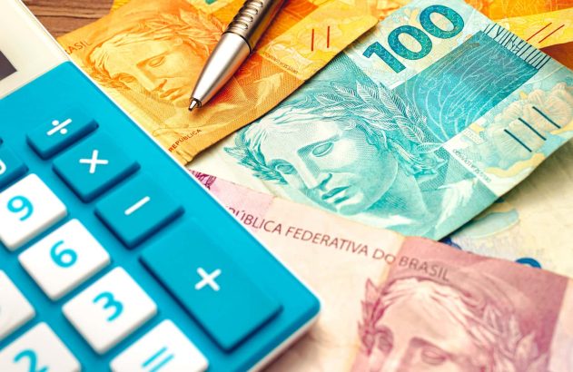 Dinheiro em espécies ao lado de uma calculadora