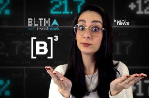 Mulher de óculos gesticula, com expressão interrogativa, diante de painel financeiro com '[B]³' e dados.