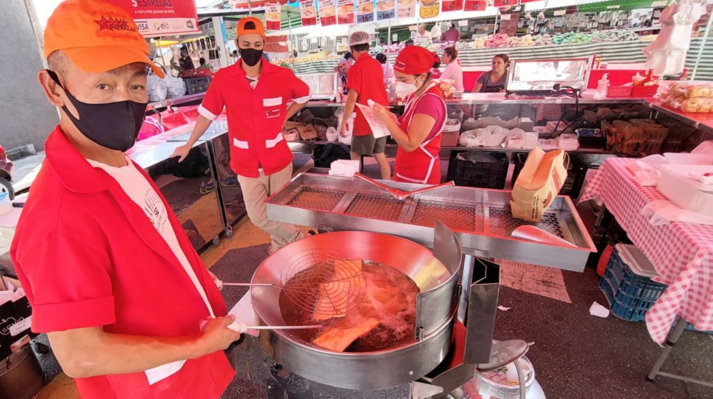 Trabalhadores fritando pastel de feira