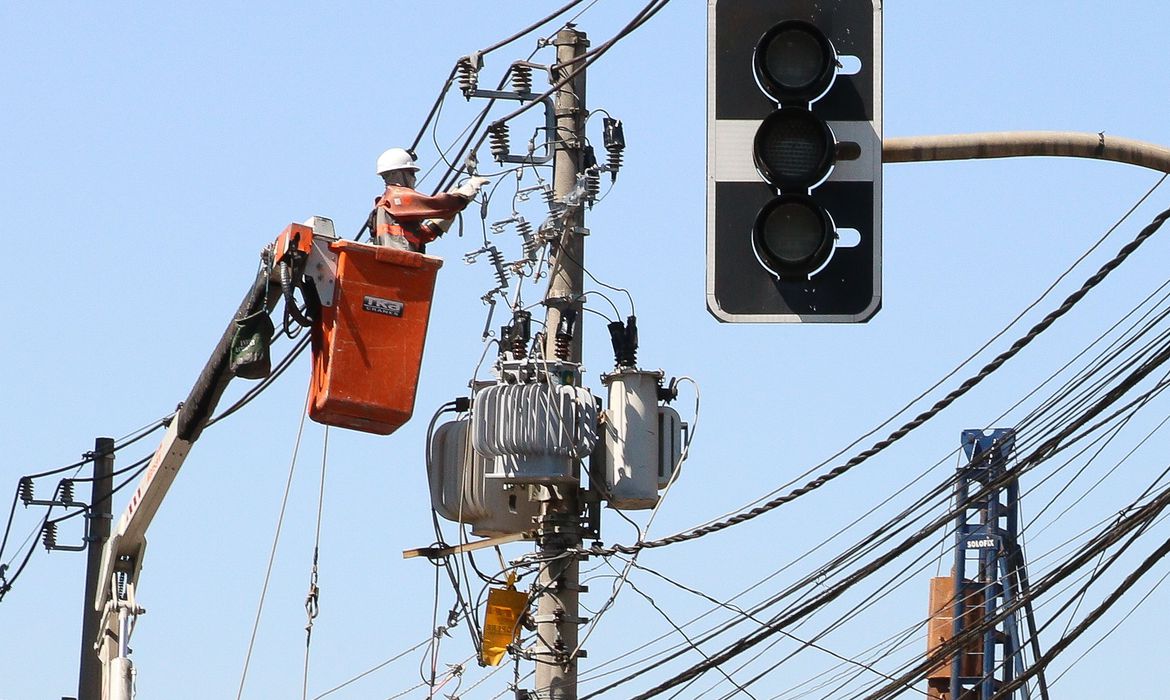 Funcionários da Enel fazem manutenção em poste de energia elétrica em São Paulo. (Foto: Rovena Rosa / Agência Brasil)