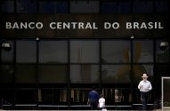 Fachada do Banco Central do Brasil e pessoas caminhando.