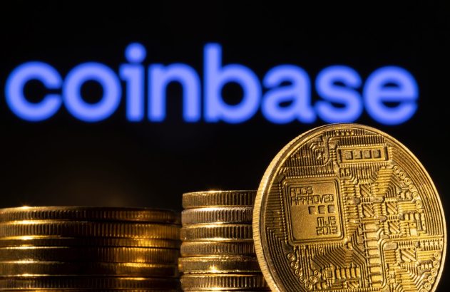 Moedas douradas empilhadas, uma com design de circuito, e o logo azul "Coinbase" no fundo desfocado.