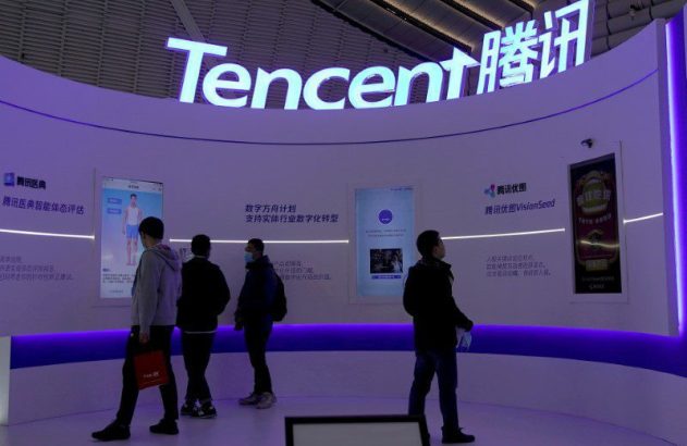 Pessoas observam displays da Tencent em estande de exposição, mostrando serviços digitais e IA.