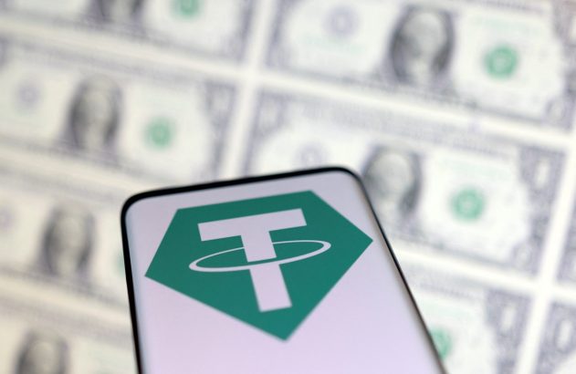 Smartphone exibe o logo do Tether (USDT) com notas de dólar dos EUA borradas ao fundo.