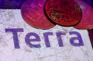 Tela de dispositivo rachada com moedas de cripto vermelhas e a palavra 'Terra' em roxo.