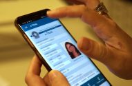 Pessoa usa smartphone com app e-Título da Justiça Eleitoral, exibindo dados de eleitor e foto.