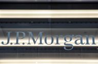 Logotipo "J.P. Morgan" em vidro, com iluminação em faixas de luz horizontais.