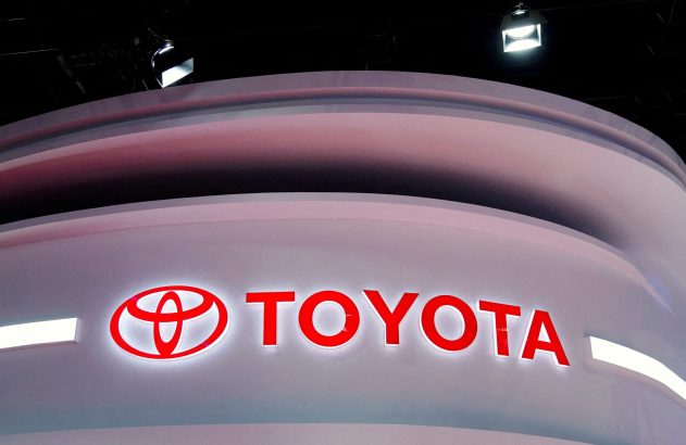Logotipo vermelho e branco da TOYOTA em um estande curvo iluminado.