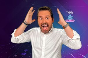 Dois homens sorrindo olham para a câmera em um estúdio com laptops à frente.