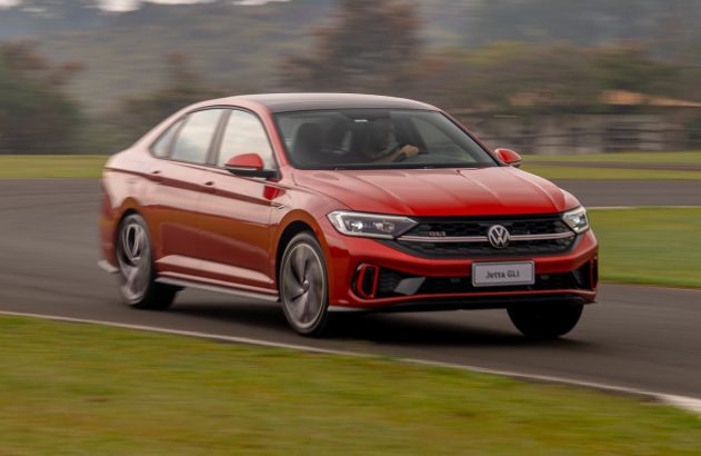 Carro vermelho em alta velocidade numa pista de corrida, com o fundo desfocado.