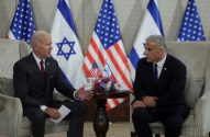 Presidente Joe Biden e Primeiro-Ministro Yair Lapid sentados, em reunião, com bandeiras dos EUA e Israel.
