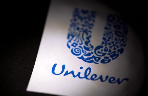 Logotipo azul da Unilever (símbolo e nome) em papel branco, parcialmente iluminado.