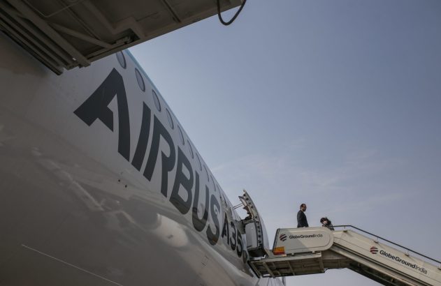 Lateral de um Airbus A350. Um homem em terno desce as escadas de embarque do avião.