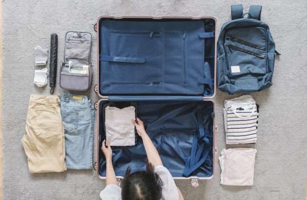 Foto de uma mala sendo arrumada. Ilustrando o tema: planilha de viagem