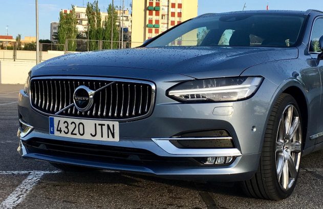 Carro Volvo cor grafite molhado, visto em primeiro plano. Gotas de água na lataria e placa 4320 JTN visível.