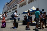 Embarque de cruzeiro no Pier Mauá: Pessoas com bagagens aguardam ao lado de um navio.
