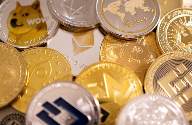 Pilha de moedas físicas de criptomoedas como Bitcoin, Ethereum e Dogecoin, em tons dourados e prateados.