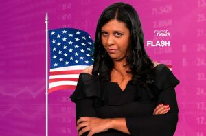 Mulher de vestido preto, braços cruzados, com bandeira dos EUA e fundo de dados financeiros e logos 'invest news' e 'FLASH'.