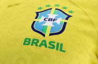 Camisa de futebol amarela do Brasil com gola verde e azul, escudo da CBF, estrelas e "BRASIL".