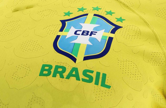Camisa de futebol amarela do Brasil com gola verde e azul, escudo da CBF, estrelas e "BRASIL".