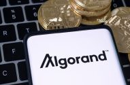 Aparelho celular com a imagem do logo da criptomoeda algorand sobre teclado de computadoromoeda algorand