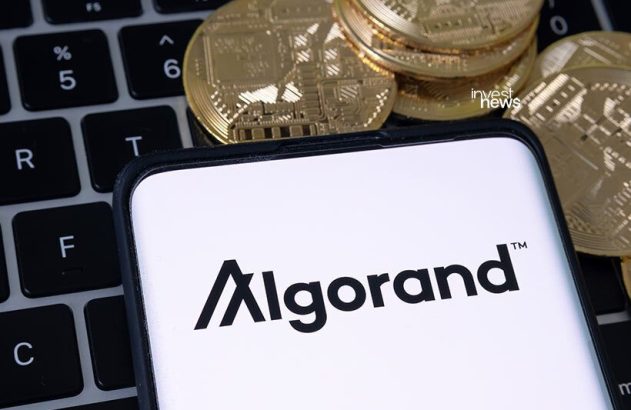 Aparelho celular com a imagem do logo da criptomoeda algorand sobre teclado de computadoromoeda algorand