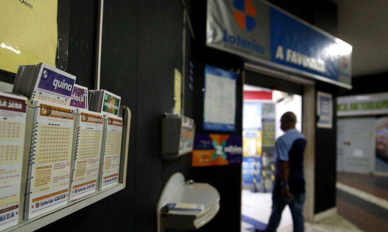 Homem entra em lotérica da Caixa, com formulários de jogos (Quina, Lotofácil) em primeiro plano.