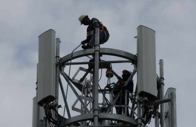 Técnicos trabalham em torre de telefonia