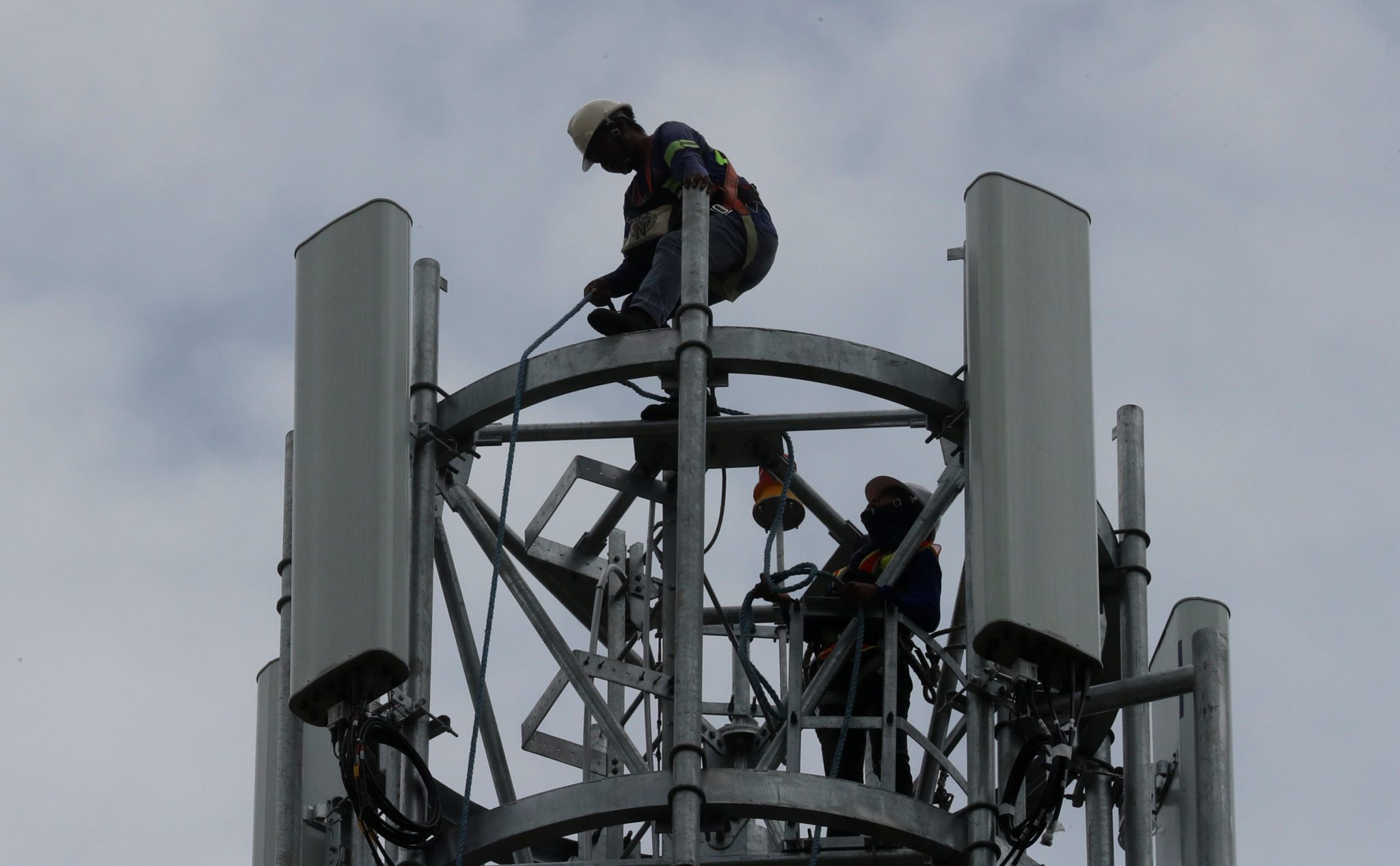 Técnicos trabalham em torre de telefonia