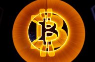 Logotipo Bitcoin laranja luminoso em fundo escuro, com efeito radial.