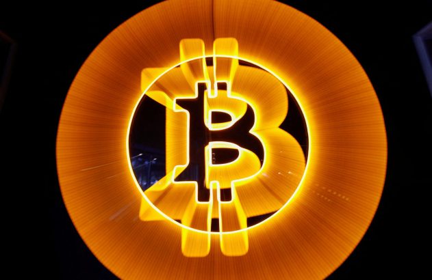 Logotipo Bitcoin laranja luminoso em fundo escuro, com efeito radial.