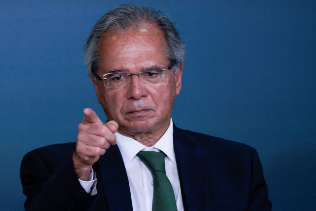 paulo guedes, ministro da economia, aponta para a frente