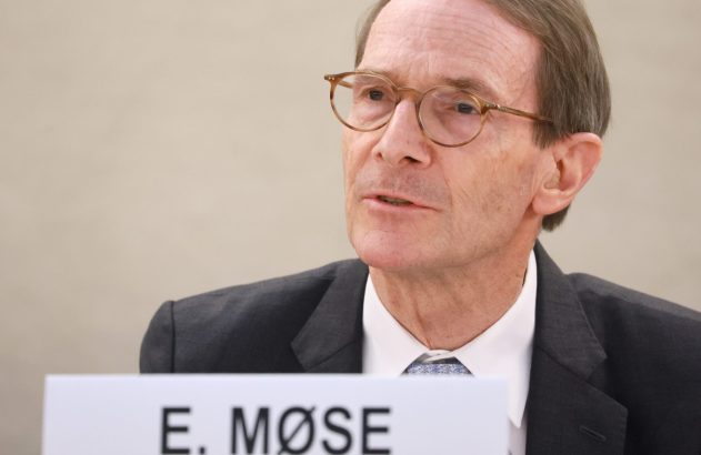 Homem de óculos e terno escuro fala em evento, com placa de identificação "E. MØSE" em primeiro plano.