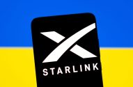 Smartphone exibe o logotipo da Starlink, com a bandeira da Ucrânia (azul e amarelo) ao fundo.