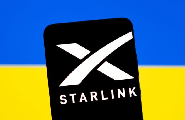 Smartphone exibe o logotipo da Starlink, com a bandeira da Ucrânia (azul e amarelo) ao fundo.