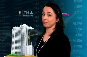 Mulher em frente a gráficos financeiros e maquete de prédios. Logos BLTMA e investnews.