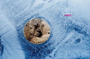 Bitcoin dourado e reluzente incrustado em um bloco de gelo translúcido com muitas bolhas.