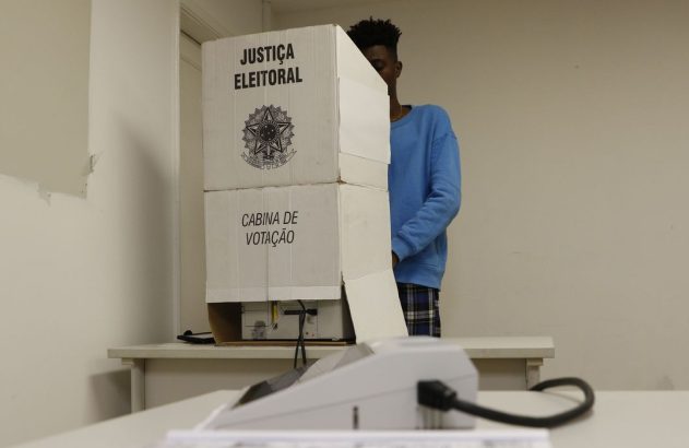 homem atras da cabine de votacao das eleições
