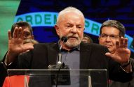 Lula discursa em pódio, mãos levantadas. Fundo com "Ordem e Progresso".