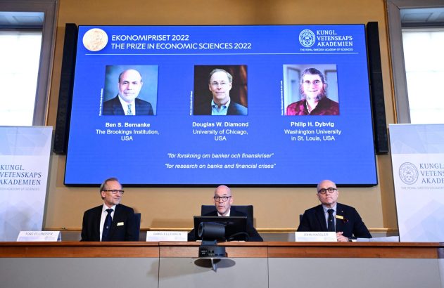 Prêmio em Ciências Econômicas 2022: tela com fotos de Bernanke, Diamond, Dybvig e 3 homens em conferência.