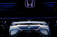Carro-conceito Honda SUV e: Prototype branco com iluminação LED em exposição. Grande logo Honda acima.