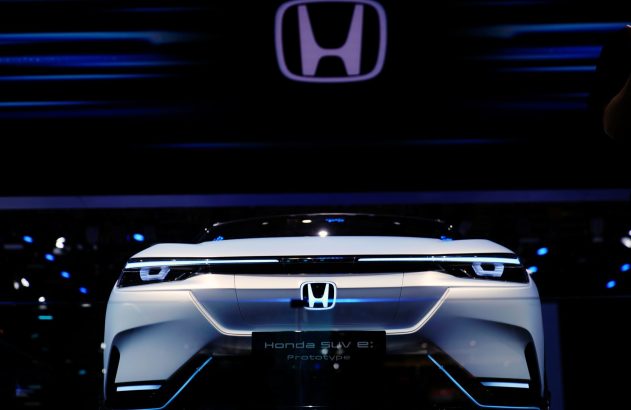 Carro-conceito Honda SUV e: Prototype branco com iluminação LED em exposição. Grande logo Honda acima.