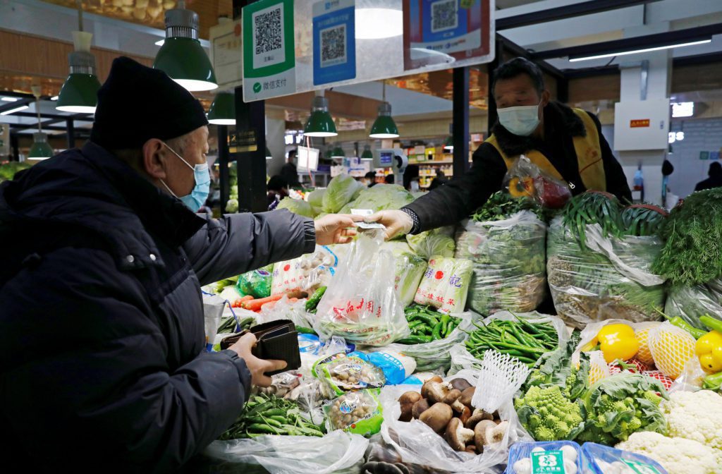 pessoas fazendo compras em feira na china