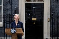 Liz Truss discursando em pódio à frente do nº 10 de Downing Street, Londres.