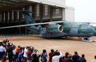 Aeronave militar KC-390 da Força Aérea Brasileira sendo fotografada por jornalistas durante evento.