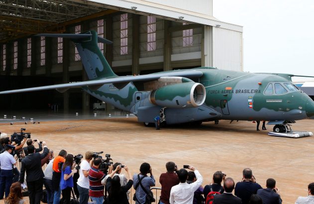 Aeronave militar KC-390 da Força Aérea Brasileira sendo fotografada por jornalistas durante evento.